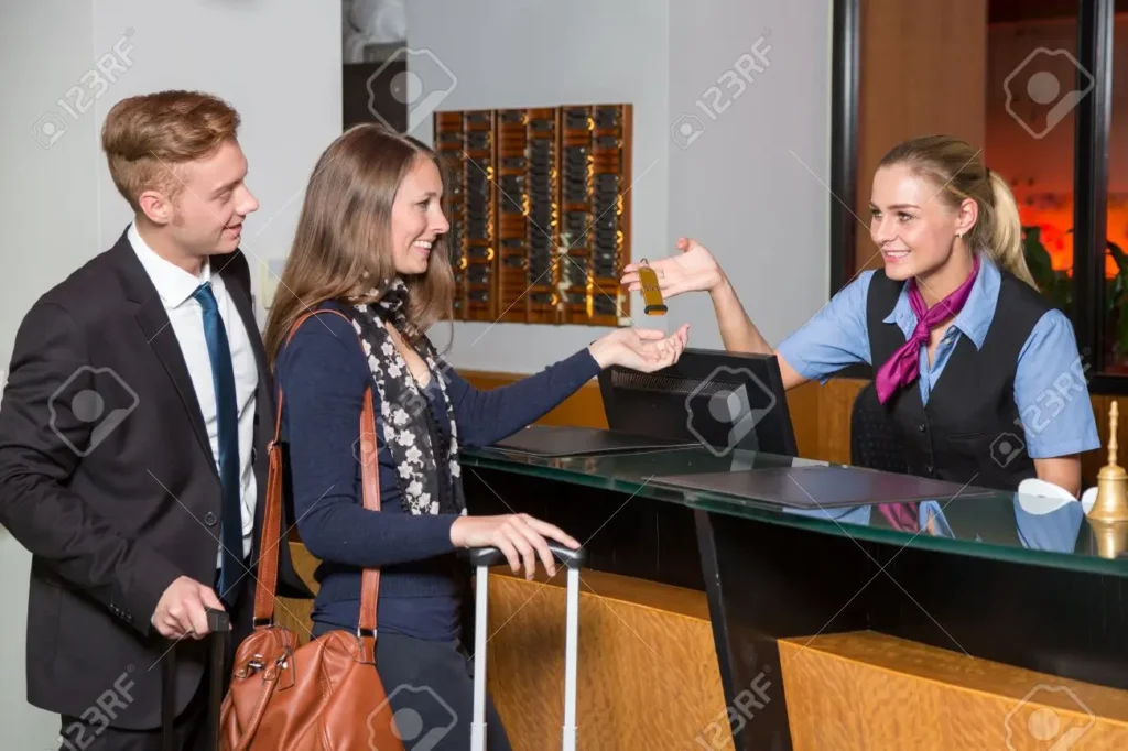 47489039 Receptionist At Hotel Reception Handing Over A Key To Guest Or Customer 1024x682.webp